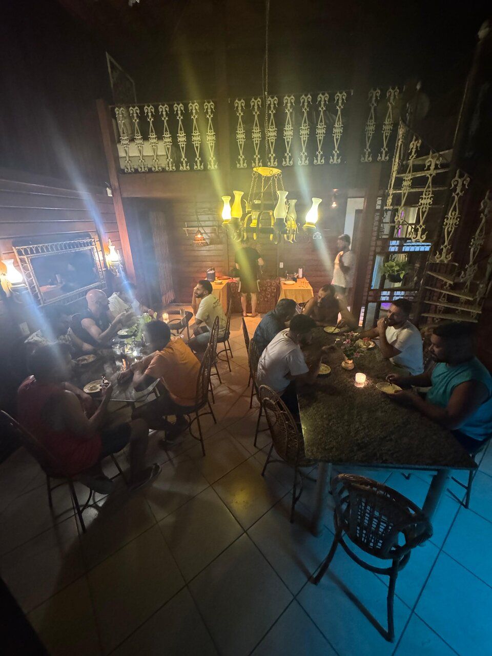 Jantar noturno no Espaço Néktar com luzes douradas e mesas amplas