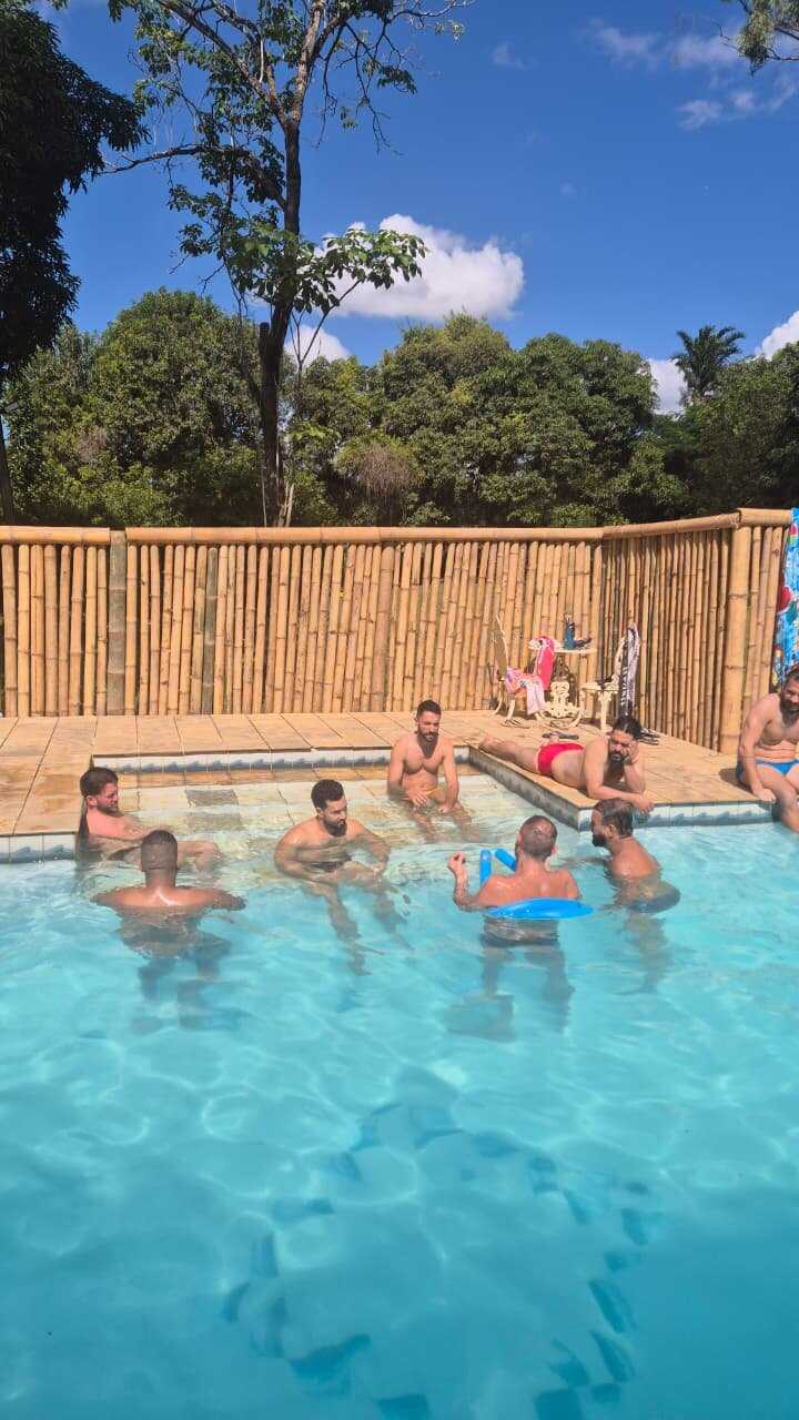 Grupo tomando banho na piscina sob o céu azul