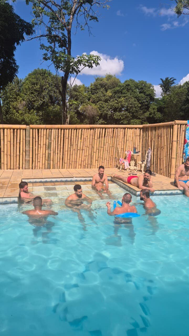 Grupo em banho de piscina sob céu azul no Espaço Néktar