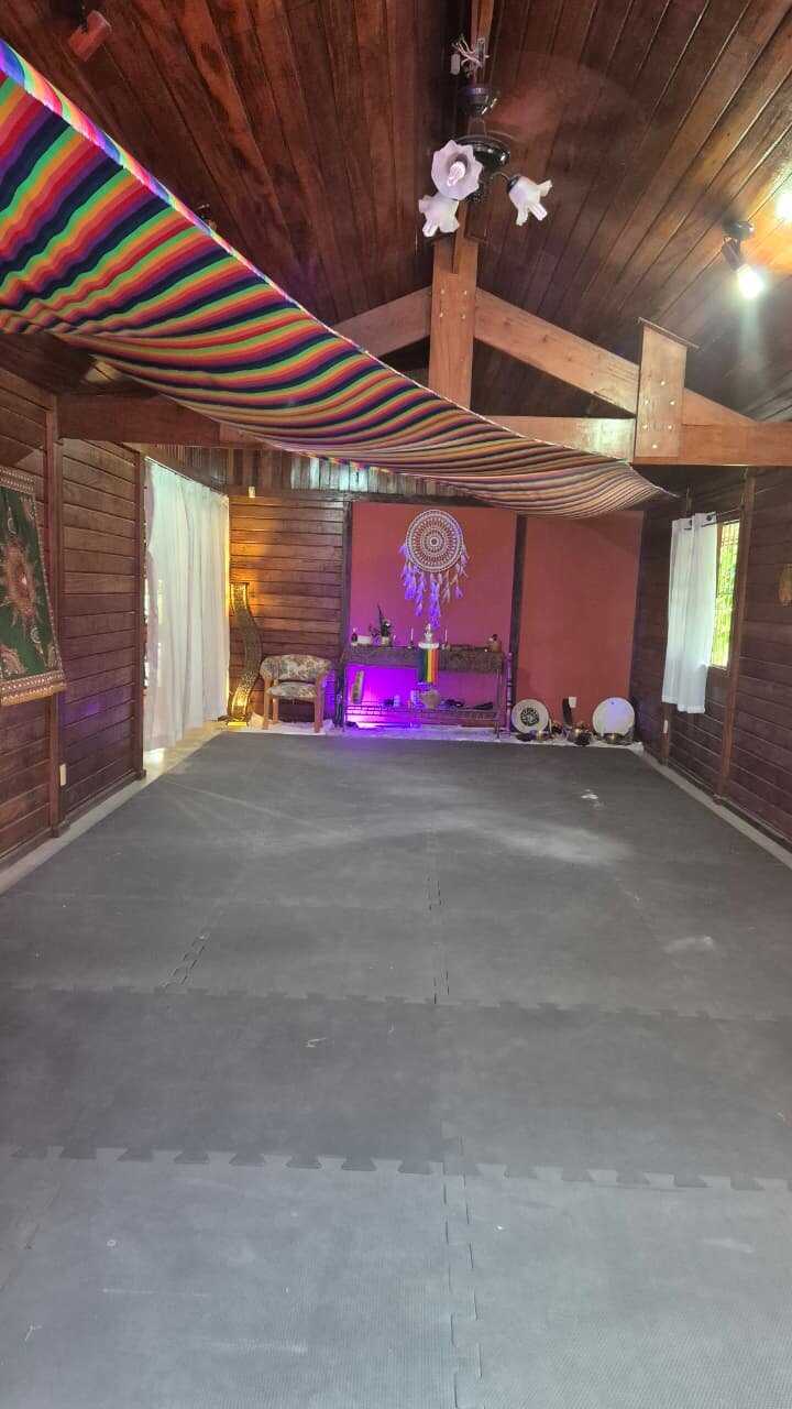 Sala de rituais em círculo, com tatame, almofadas e altar com mandala